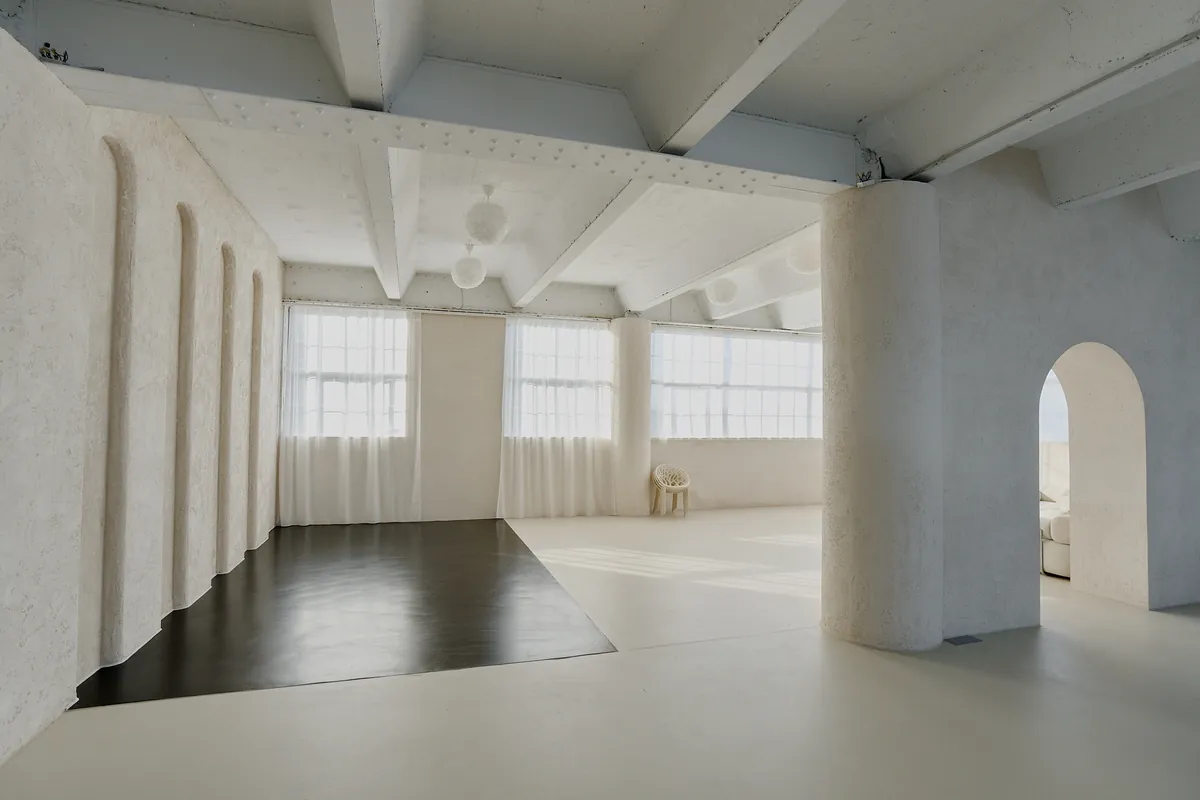 Gaia Studio — Rundbogen-Wand mit Tageslicht und schwarzem Designboden