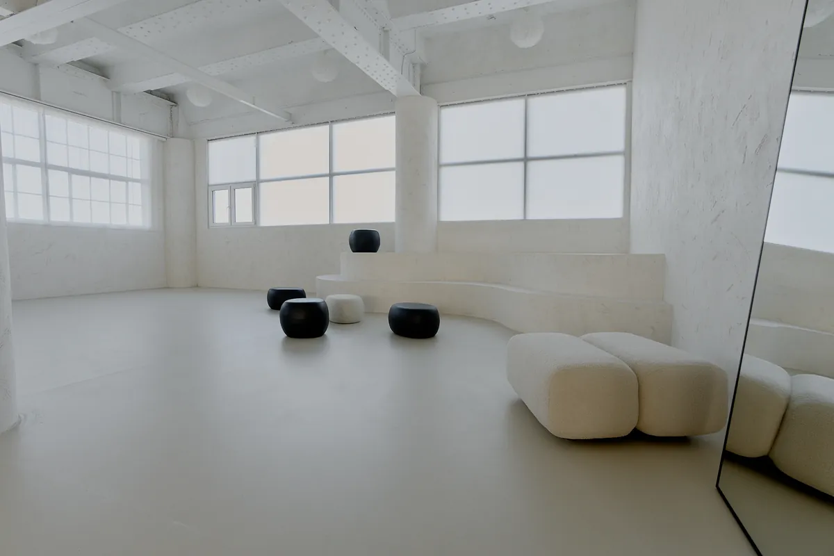 Gaia Studio — heller Raum mit Poufs und geschwungener Sitzbank